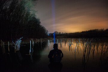 Obraz premium human on the lake forest in the night . Night landscape. Nightsky and clouds . Stars in the sky . Lights of the city . Evening forest . Landscapes of Ukraine . Night and morning time 