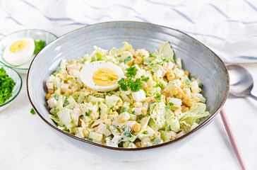 Festive salad with ham, cucumber, boiled eggs, sweet corn and mayonnaise on rustic.