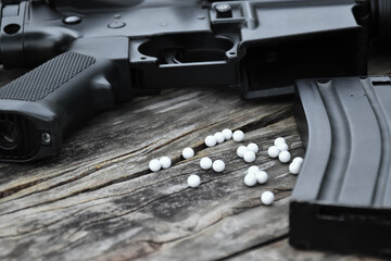 Closeup of white plastic bullets of airsoft gun or bb gun on wooden floor, soft and selective focus...
