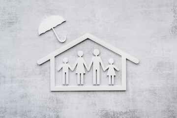 Wooden family figure under umbrella. Health and live insurance concept