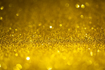 Gold glitter lights. Shiny sparkles, bokeh effects, glowing surface. Selective focus, christmas abstract background