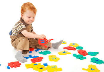 A little boy is playing with an educational puzzle