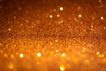 Orange glitter lights. Shiny sparkles, bokeh effects, glowing surface. Selective focus, christmas...