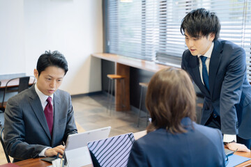 ノートパソコンで会議をする３人の男女のビジネスマン