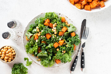 Healthy vegan salad bowl with roasted sweet potato and kale, table top view