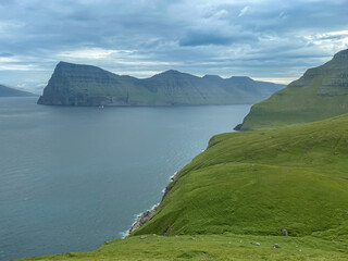 Beautiful aerial view of the Kallur Lighthouse in the Faroe Islands, and its massive cliffs, crags hikes and ocean views
