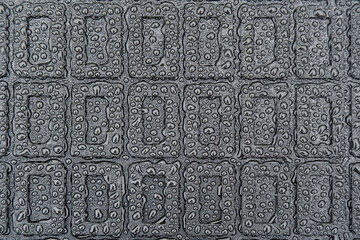 The texture of a black rubber car mat in water droplets.Abstract geometric image on a rubber base.
