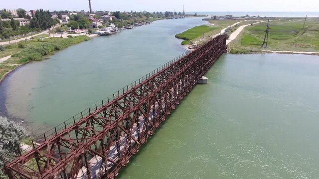 Aerial shot of Arabat arrow with a cribrate bridge, local road, houses and water