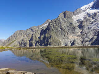 Fototapeta na wymiar Panorama of the La Meije massif with reflection in a water reservoir