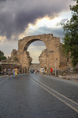 The entrance gate of the ancient city of Side, the Vespasianus Monument and ancient theater. Selective Focus ruins . Cloudy blue Sky. 02-07-2021 Antalya. 