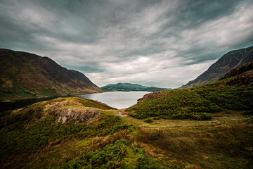 A landscape photograph overlooking Crummock Water and the northern fells of Buttermere Valley in the Lake District, Cumbria.