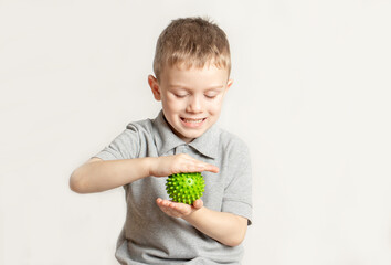 The child performs an exercise with a relief ball the development of tactile sensations. An...