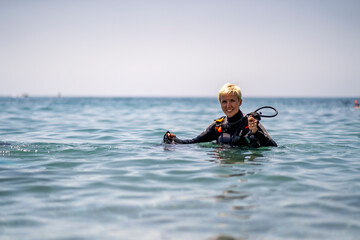 Happy woman getting ready to scuba diving in the Mediterranean Sea
