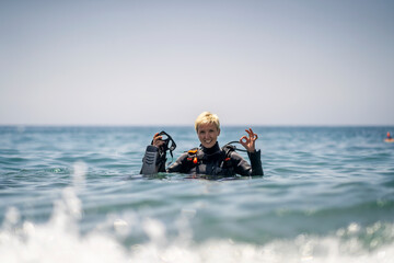 Happy woman getting ready to scuba diving in the Mediterranean Sea