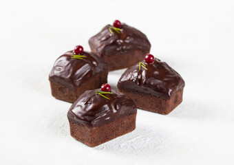 Dessert rectangular chocolate cake, muffin with icing and cranberries on a white background