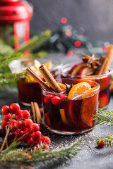 Glass mugs of mulled wine with spices and citrus fruits. Traditional hot drink or beverage, festive...