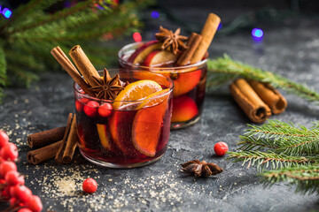 Glass mugs of mulled wine with spices and citrus fruits. Traditional hot drink or beverage, festive...