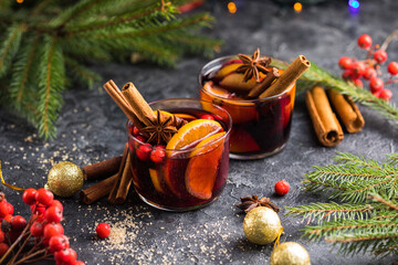 Glass mugs of mulled wine with spices and citrus fruits. Traditional hot drink or beverage, festive...