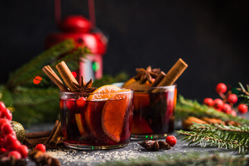Glass mugs of mulled wine with spices and citrus fruits. Traditional hot drink or beverage, festive...