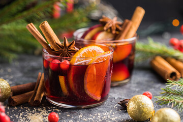 Glass mugs of mulled wine with spices and citrus fruits. Traditional hot drink or beverage, festive...
