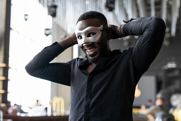 Smiling African American man wearing fantasy face mask for celebration in his company
