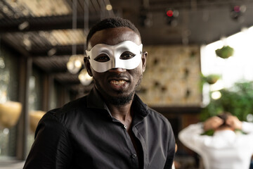 Smiling African American man wear fantasy face mask for celebration in his company