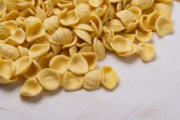 Yellow orecchiette pasta on wooden table