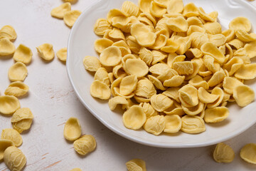 Yellow orecchiette pasta on wooden table