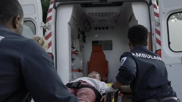 Team of paramedics pulling stretcher with indian kid