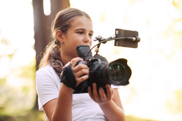 Cute girl shooting a video with a professional video camera