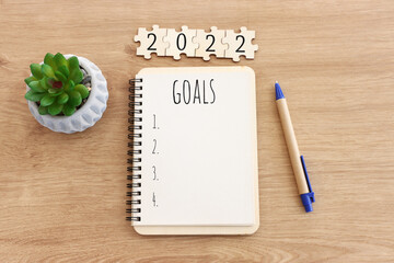 Business concept of top view 2022 goals list with notebook over wooden desk