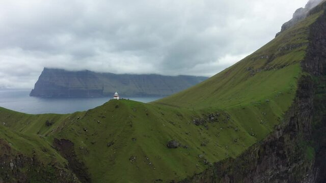 Kallur lighthouse on green hills of Kalsoy island. Faroe Islands Landscape. Atlantic coast of the Faroe Islands. High quality 4k footage
