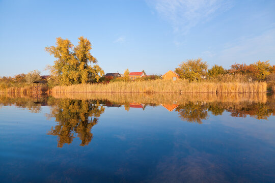 Beautiful autumn landscape perfectly reflected in the river on a sunny day.