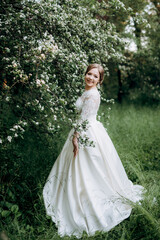 Obraz na płótnie Canvas bride with a wedding bouquet in the forest