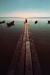 Obraz premium Young Man Time Passing on Wooden Pontoon