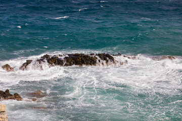  Rocks. White frothy  waves hitting a rock by the seashore. Stock Image.