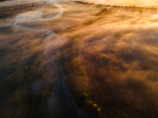 A magical dawn. Autumn fog covers fields and lakes. Long shadows from the trees. Photo from the drone. High quality photo