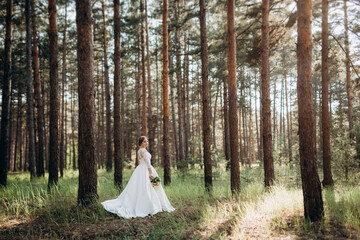 the bride walking in a pine forest