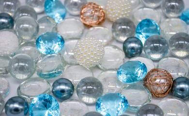 Beautiful background of transparent, light blue glass beads, crystals and white pearls. Copy space