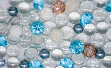 Beautiful background of transparent, light blue glass beads, crystals and white pearls. Copy space
