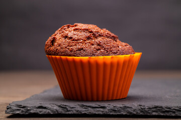 a chocolate cupcake in a silicone mold on a dark slate side view