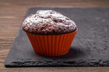 chocolate cupcake in silicone mold sprinkled with powdered sugar