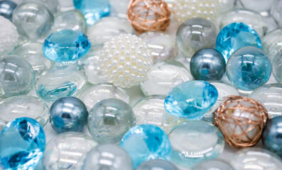 Beautiful background of transparent, light blue glass beads, crystals and white pearls. Copy space