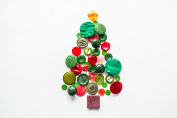 A Christmas tree made of buttons of green, red color. white background, copy space. Creative Christmas Concept