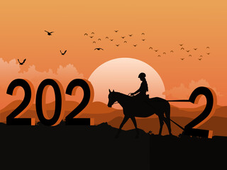 Silhouette of a woman riding a horse using a rope to drag the number two up the mountain. The number 2022 on it has mountains and sunset in the background.