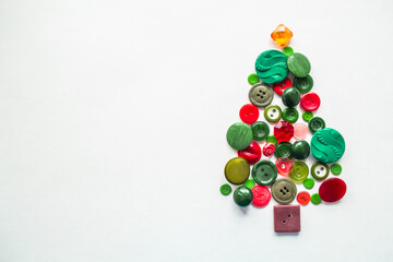 A Christmas tree made of buttons of green, red color. white background, copy space. Creative...