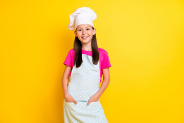 Photo of confident nice girl hands pockets finish dinner wear white apron hat isolated yellow color background