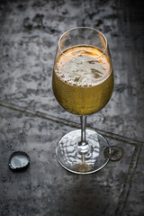 Sparkling cider in wine glass on textured grey clay background