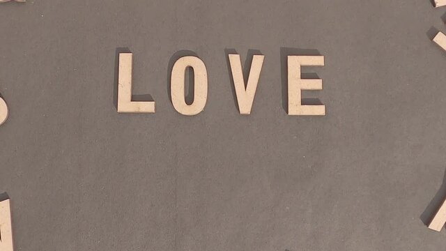 Love Work In Wooden Cube Alphabet Letters Top View On A rustic paper Background.