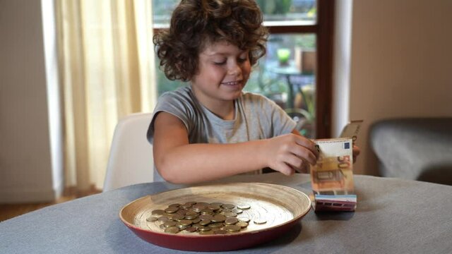 Boy child 7 years old count money euro cash banknotes and coins - savings accumulated over the years - learn economics and counting numbers